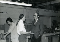 Workshop [Senior Work Center], Item 23: Mr. Nambu (center) talks with Dr. Bruce Douglas, Illinois state representative, who is visiting the work center. Workshop supervisor Pauline Yoshioka is at the far left