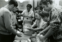 Nutrition Program, Item 7, front: (foreground, L to R) Korean client (unidentified), Mr. Besho (wearing glasses), Mrs. Hattori (holding two plates), and Mrs. Orita (second from right)