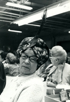 Blood Assurance, Communal Living, Issei Work Center, Body Dynamics, Annual Community Picnic, and Market Day, Item 18, front: Mrs. Hirota models her Easter Parade hat. Participants made hats and ties from materials available in the work center